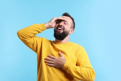 Photo of Handsome man laughing on light blue background