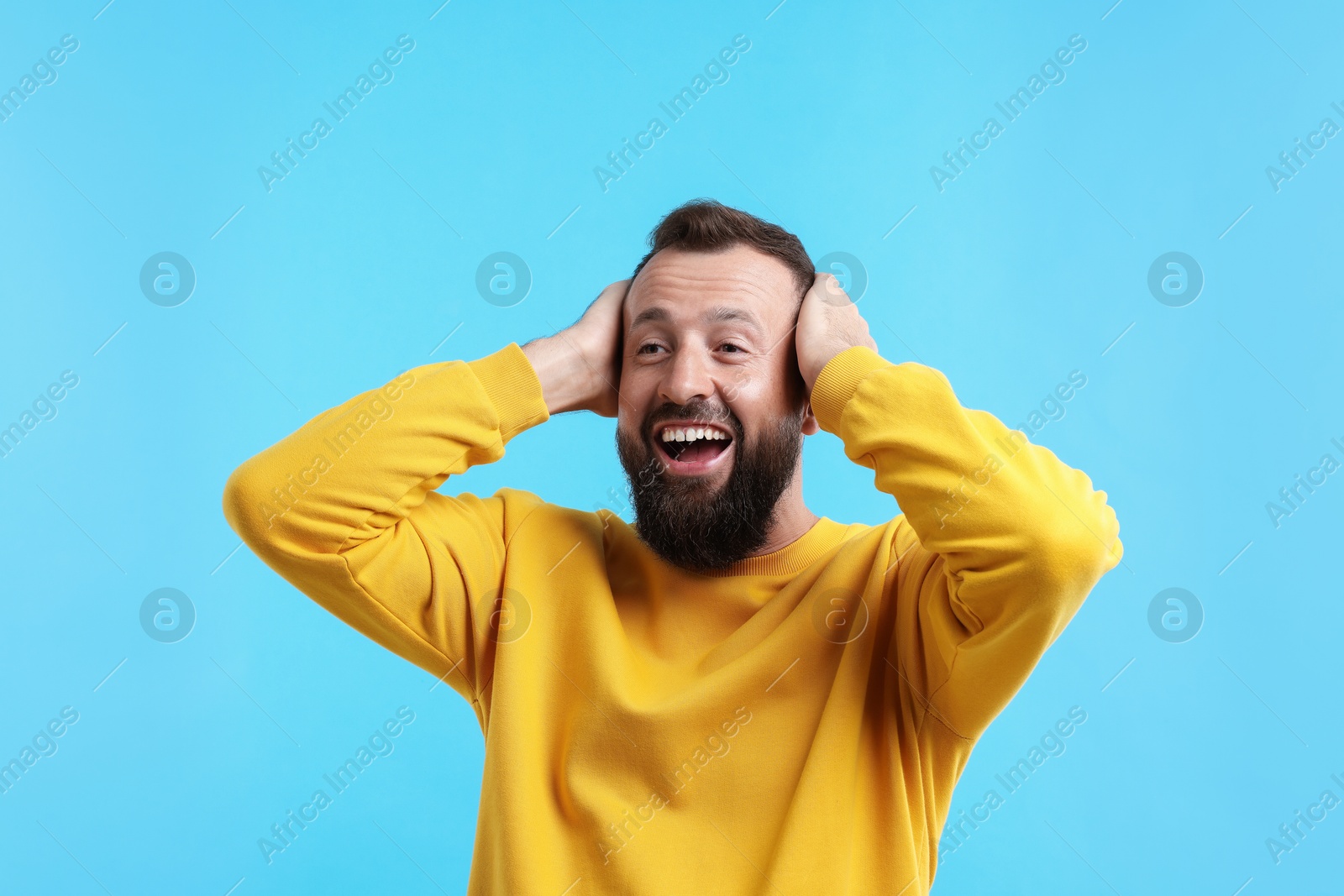 Photo of Handsome man laughing on light blue background