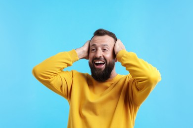 Photo of Handsome man laughing on light blue background