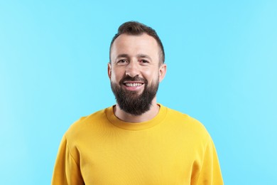 Photo of Handsome man laughing on light blue background