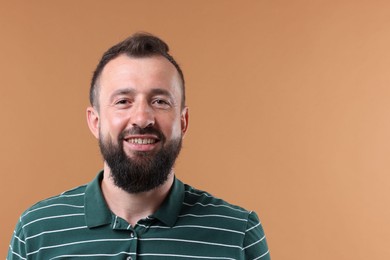 Photo of Handsome man laughing on brown background. Space for text
