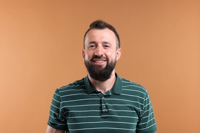 Photo of Handsome man laughing on brown background. Positive emotion