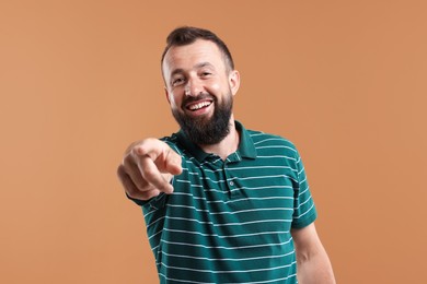 Photo of Handsome man laughing on brown background. Positive emotion
