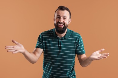 Photo of Handsome man laughing on brown background. Positive emotion