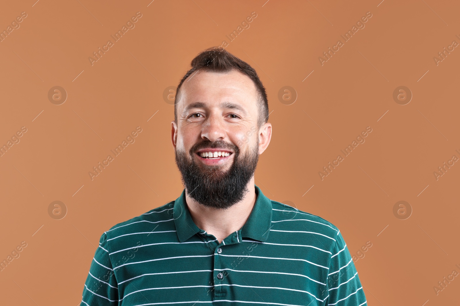 Photo of Handsome man laughing on brown background. Positive emotion