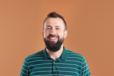 Photo of Handsome man laughing on brown background. Positive emotion