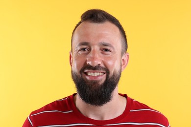 Photo of Handsome man laughing on yellow background. Positive emotion