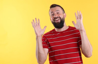 Photo of Handsome man laughing on yellow background. Positive emotion