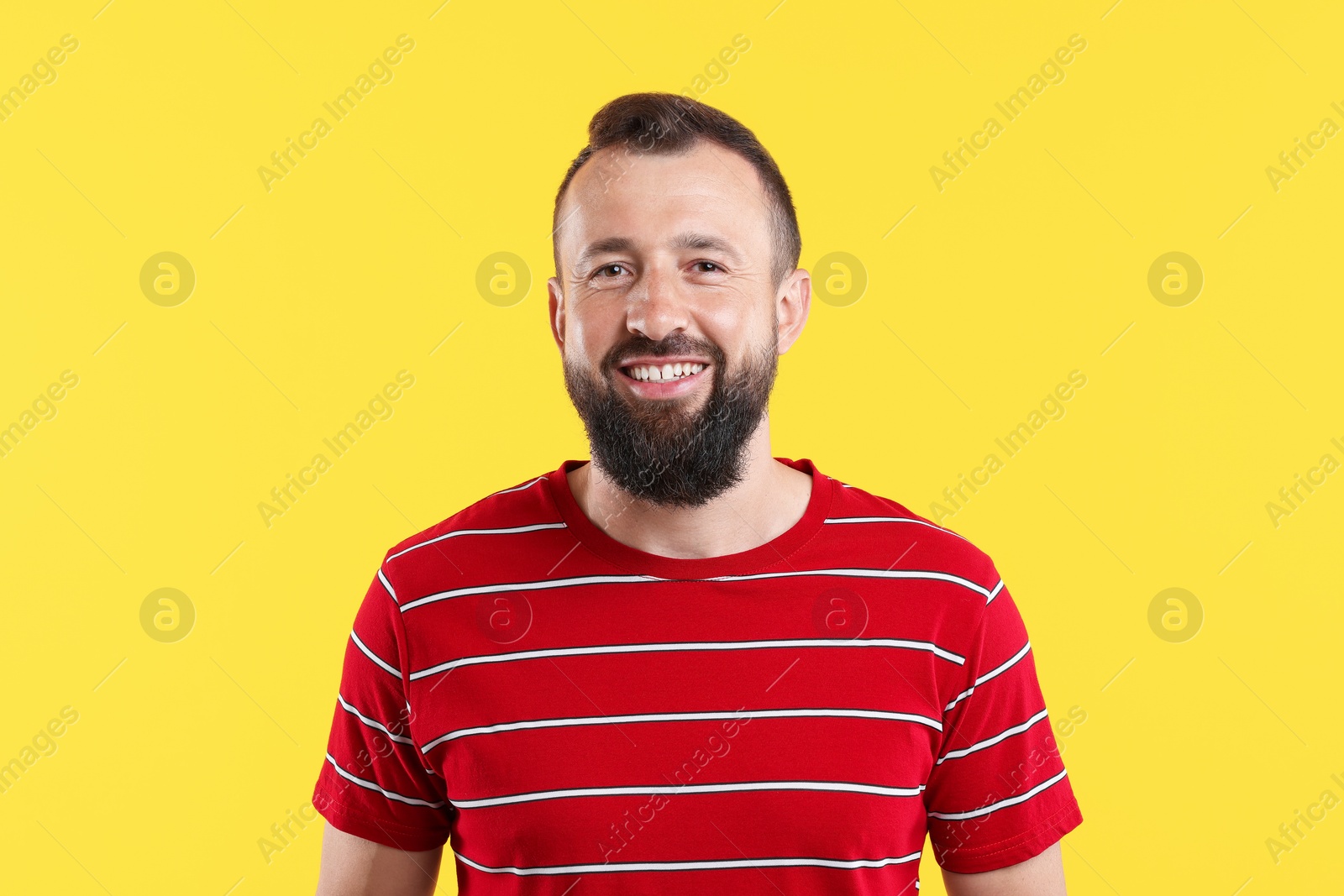Photo of Handsome man laughing on yellow background. Positive emotion