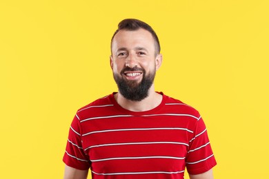 Photo of Handsome man laughing on yellow background. Positive emotion