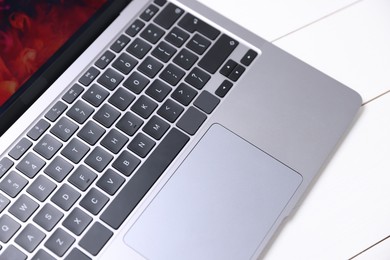 Photo of Laptop keyboard on white wooden table, above view