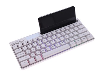 Photo of Modern computer keyboard with RGB lighting and smartphone isolated on white, above view