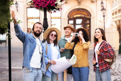 Photo of Guide with headset and group of tourists on city street during excursion