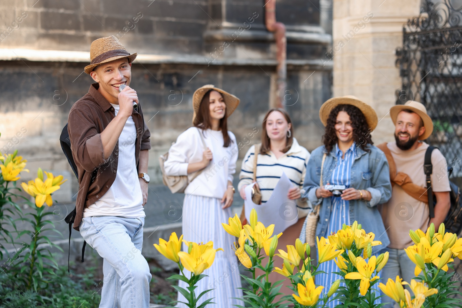 Guide with microphone and group of tourists on city street during excursion Photo of Guide with microphone and group of tourists on city street during excursion