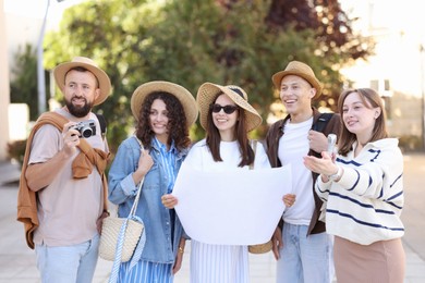Photo of Guide with microphone and group of tourists on city street during excursion