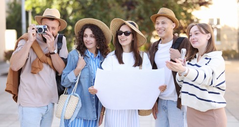 Photo of Guide with microphone and group of tourists on city street during excursion
