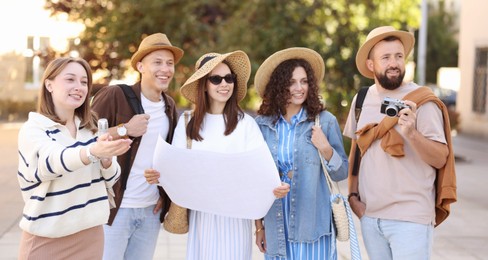Photo of Guide with microphone and group of tourists on city street during excursion