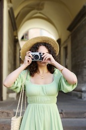 Photo of Tourist with vintage camera walking on city street