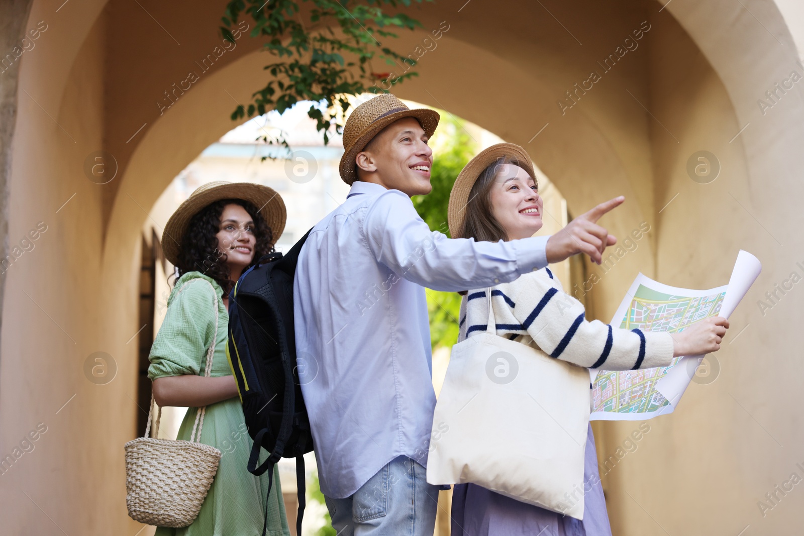 Photo of Tourists with map walking on city street, low angle view