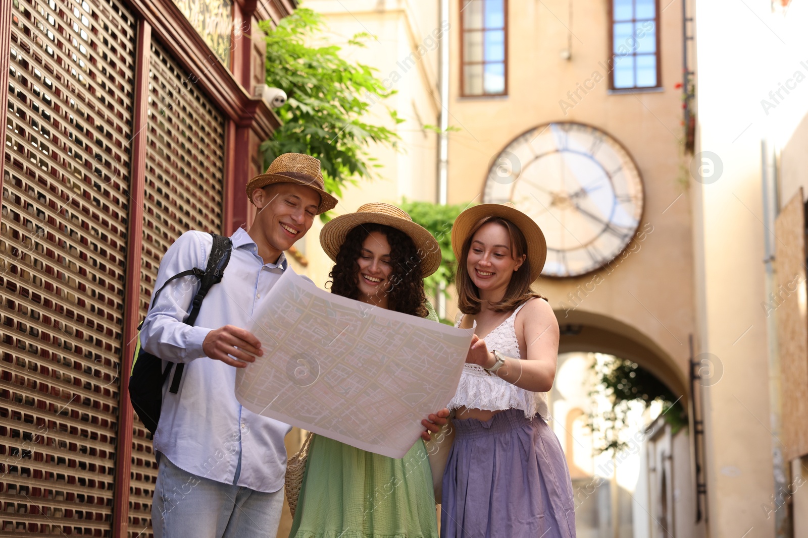 Tourists with map walking on city street, low angle view Photo of Tourists with map walking on city street, low angle view