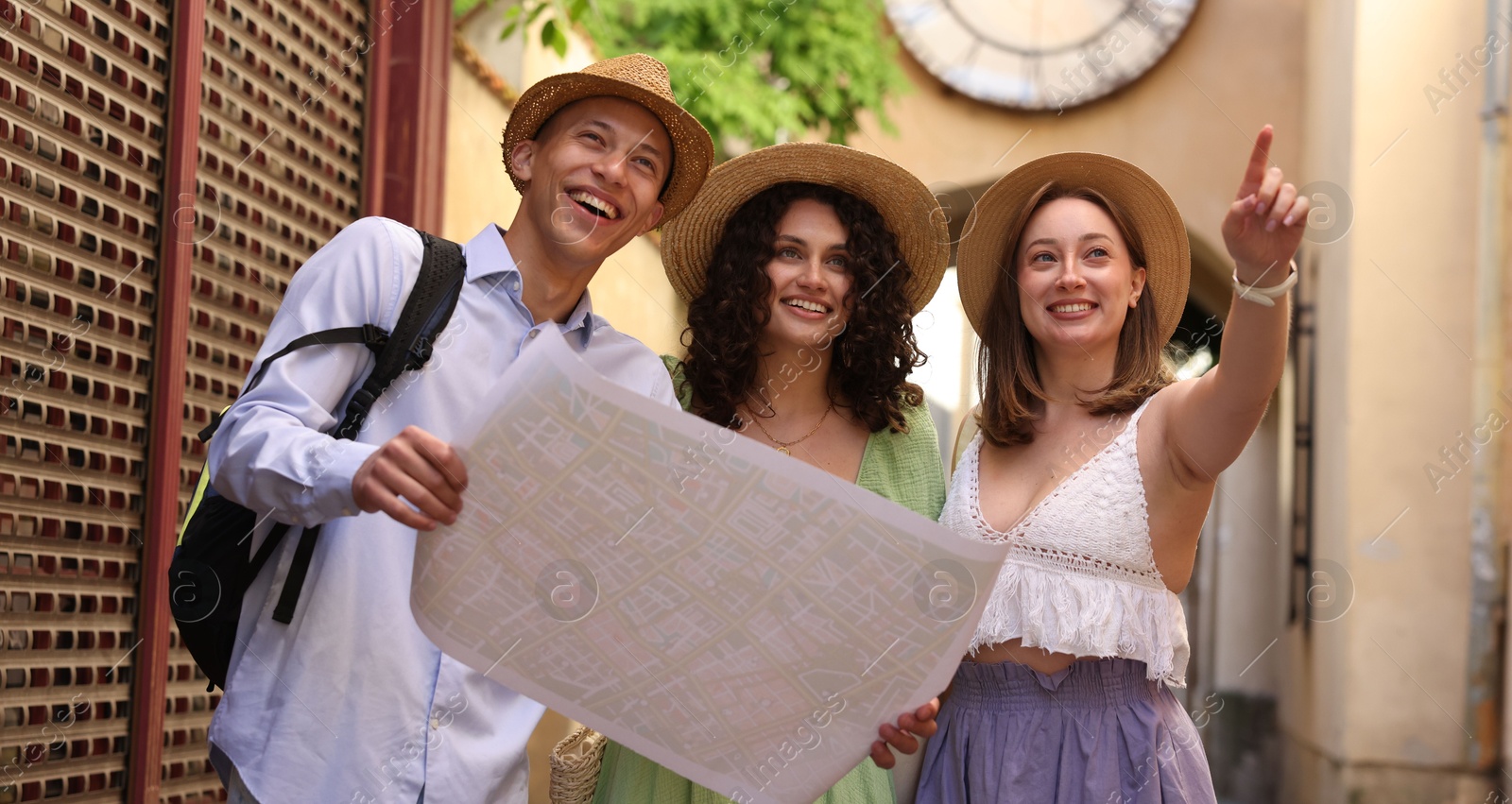 Tourists with map walking on city street Photo of Tourists with map walking on city street
