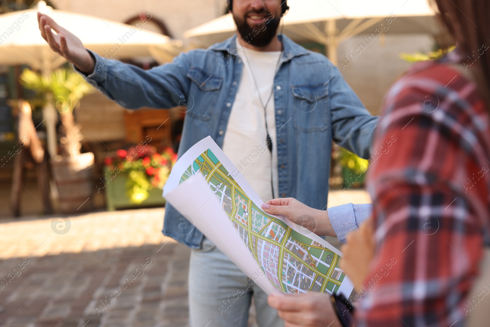Guide with headset and tourists on city street during excursion, selective focus Photo of Guide with headset and tourists on city street during excursion, selective focus