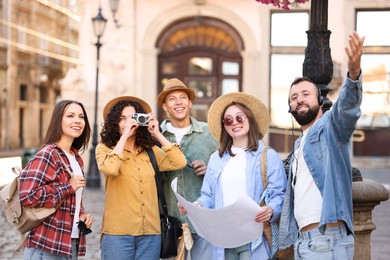 Photo of Guide with headset and group of tourists on city street during excursion