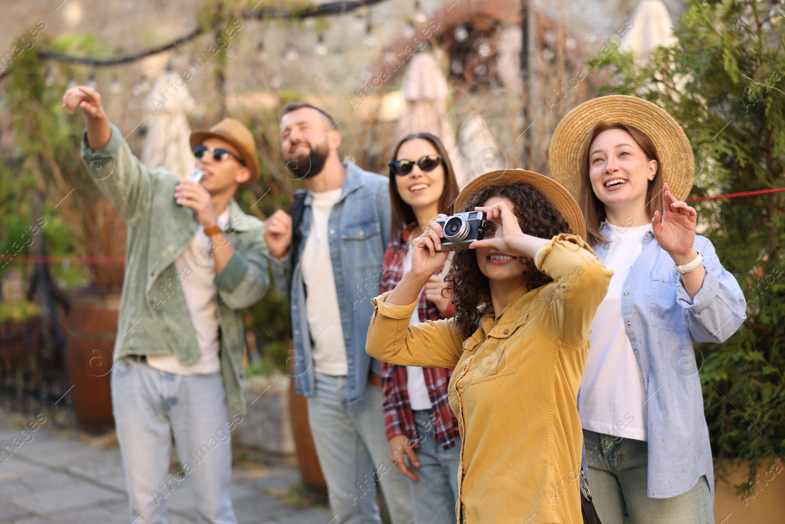 Guide with microphone and group of tourists on city street during excursion, selective focus Photo of Guide with microphone and group of tourists on city street during excursion, selective focus