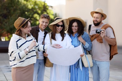 Photo of Guide with microphone and group of tourists on city street during excursion