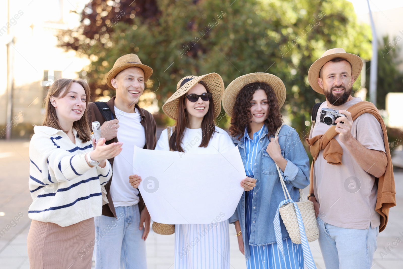 Guide with microphone and group of tourists on city street during excursion Photo of Guide with microphone and group of tourists on city street during excursion