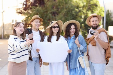Photo of Guide with microphone and group of tourists on city street during excursion