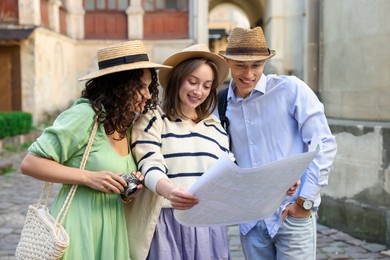 Photo of Tourists with map walking on city street