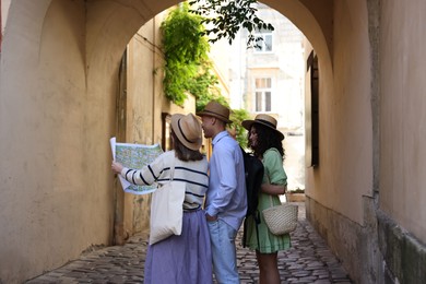 Photo of Tourists with map walking on city street