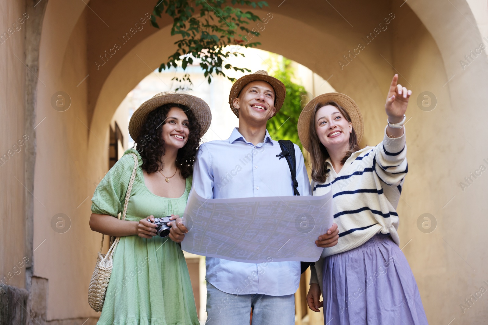 Tourists with map walking on city street, low angle view Photo of Tourists with map walking on city street, low angle view