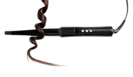 Photo of Curling iron with brown hair lock isolated on white