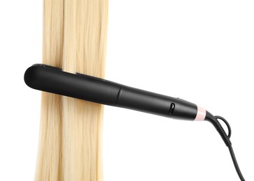 Photo of Straightener with blonde hair lock isolated on white