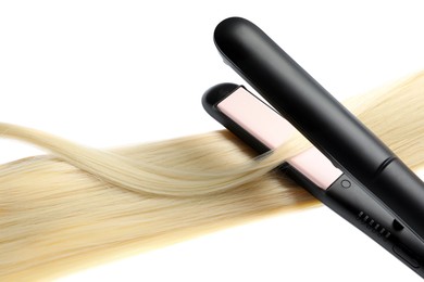 Photo of Straightener with blonde hair lock isolated on white