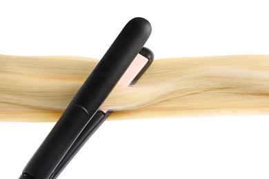 Photo of Straightener with blonde hair lock isolated on white
