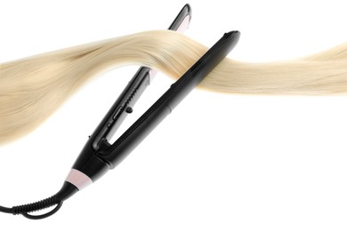 Photo of Straightener with blonde hair lock isolated on white