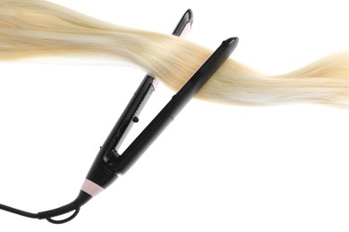 Photo of Straightener with blonde hair lock isolated on white