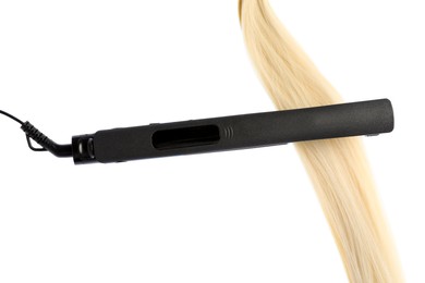 Photo of Straightener with blonde hair lock isolated on white