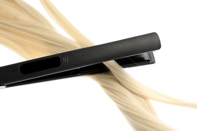 Photo of Straightener with blonde hair lock isolated on white
