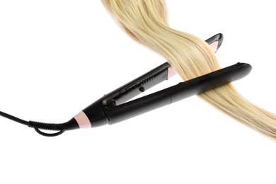 Photo of Straightener with blonde hair lock isolated on white