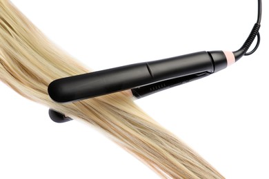 Photo of Straightener with blonde hair lock isolated on white