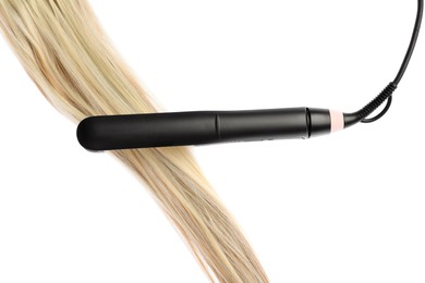 Photo of Straightener with blonde hair lock isolated on white