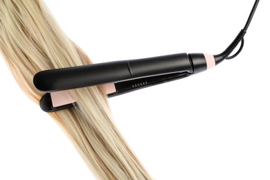 Photo of Straightener with blonde hair lock isolated on white