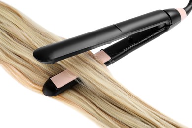 Photo of Straightener with blonde hair lock isolated on white