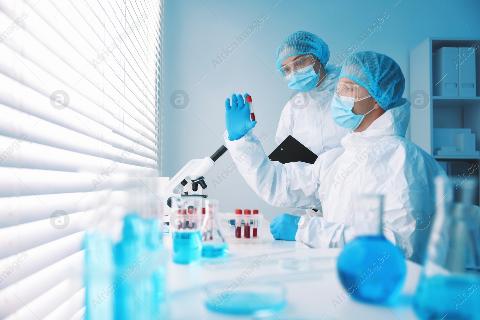 Medical analysis. Scientists working with blood sample in laboratory Photo of Medical analysis. Scientists working with blood sample in laboratory