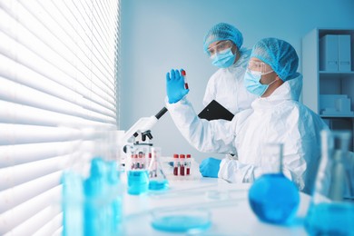 Photo of Medical analysis. Scientists working with blood sample in laboratory