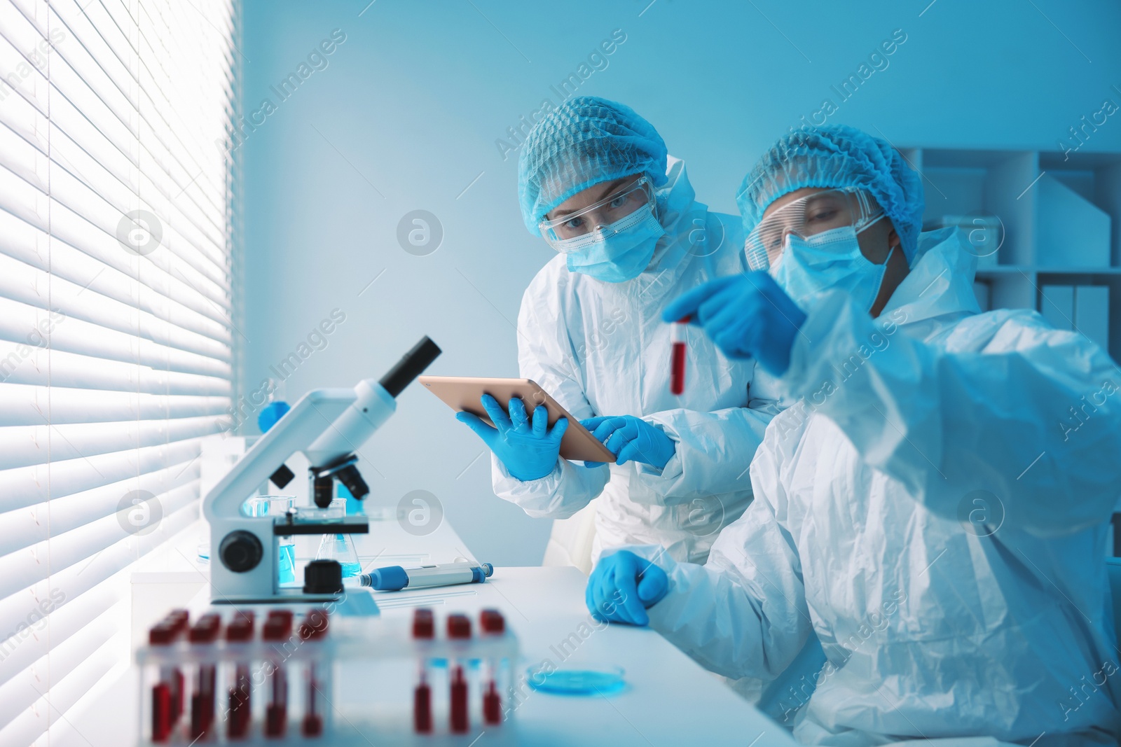 Medical analysis. Scientists working with blood sample in laboratory Photo of Medical analysis. Scientists working with blood sample in laboratory